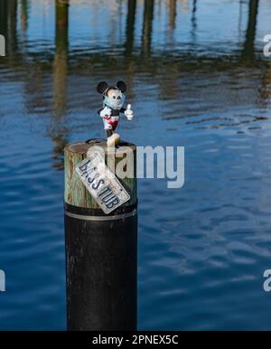 Ein Bild einer kleinen, maskierten Micky Maus-Puppe, die auf einer Säule an der San Francisco Waterfront sitzt. Stockfoto