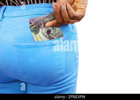 Eine Schwarze, die ein paar botswananische Pula-Noten in ihre Hosentasche steckt. Geld aus der Tasche nehmen, Geld aufbewahren Stockfoto