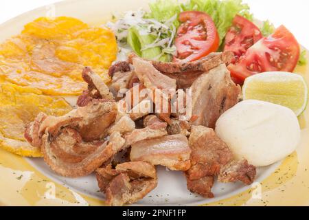 Kolumbianisches Essen, Gebratener Chicharron Begleitet Von Salat, Patacon Und Arepa. Stockfoto