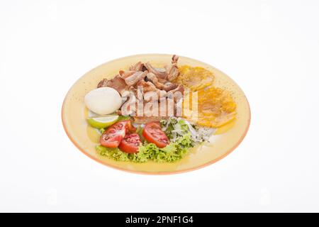 Kolumbianisches Essen, Gebratener Chicharron Begleitet Von Salat, Patacon Und Arepa. Stockfoto