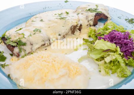 Köstliches Gegrilltes Steak Garniert Mit Käsesauce Serviert Mit Salat Und Kartoffelpüree. Stockfoto