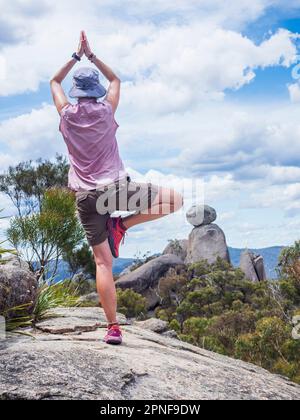 Australien, Queensland, Girraween-Nationalpark, eine Frau, die in der Wildnis einen Baum praktiziert Stockfoto