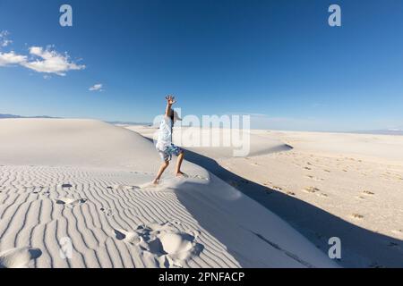 USA, New Mexico, White Sands National Park, Boy (10-11) springt auf Sanddünen Stockfoto