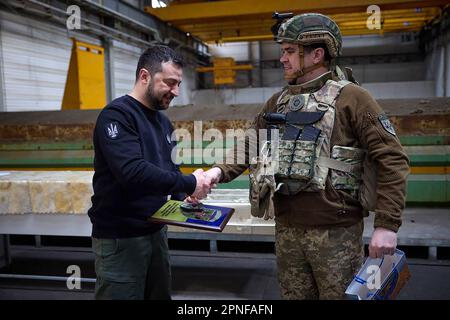 Kherson, Ukraine. 19. April 2023. Zeigt, wie der ukrainische Präsident Wolodymyr Zelensky (L) während seines Besuchs in der schwer beschießten Frontstadt Avdiivka in der Region Donezk inmitten der russischen Invasion der Ukraine am Dienstag, den 18. April 2023, Soldaten verlieh. Foto: Pressestelle des ukrainischen Präsidenten/UPI. Kredit: UPI/Alamy Live News Stockfoto