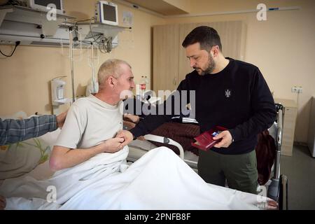 Kherson, Ukraine. 19. April 2023. Ukrainischer Präsident Wolodymyr Zelensky (R), der am Dienstag, den 18. April 2023, inmitten der russischen Invasion in der Ukraine einen verwundeten Soldaten im Militärkrankenhaus der schwer beschießten Grenzstadt Avdiivka, Region Donezk, ausstellte. Foto: Pressestelle des ukrainischen Präsidenten/UPI. Kredit: UPI/Alamy Live News Stockfoto