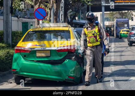 SAMUT PRAKAN, THAILAND, JANUAR 21 2023, Ein Polizist mit einem Taxifahrer in einem abgestürzten Taxi Stockfoto