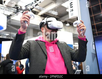 Hannover, Deutschland. 18. April 2023. Ein Mann probiert am 18. April 2023 auf der Hannover Messe in Hannover ein VR-Headset aus. Die führende Messe für Maschinenbau und Elektrotechnik in Deutschland startete am Montag in Hannover mit dem Thema „Industrielle Transformation – macht den Unterschied“. Kredit: Ren Pengfei/Xinhua/Alamy Live News Stockfoto
