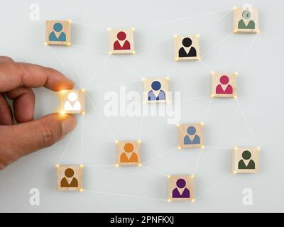 Holzblöcke mit Personensymbolen in verschiedenen Farben. Aufbau oder Entwicklung eines starken Teams, Personalwesen und Managementkonzepts, HR und HRM Stockfoto