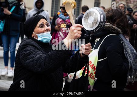 Paris, Frankreich. 18. April 2023. Eine ältere Frau schlägt während der Demonstration auf die Pfanne. Mehr als 300 Menschen versammelten sich heute Abend in Saint-Denis, Paris, wo Emmanuel Macron an einem Konzert in der Ehrenlegion teilnehmen sollte. Der Protest fand auf einem überfüllten Rathausplatz in der Nähe der Basilika von Saint-Denis statt, wo die Autokolonne des Präsidenten auftauchte. Kredit: SOPA Images Limited/Alamy Live News Stockfoto