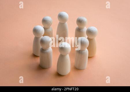 Die Holzpuppen stehen im Kreis und sehen einander gegenüber. Teamentscheidung oder Konzept der Zusammenarbeit. Stockfoto