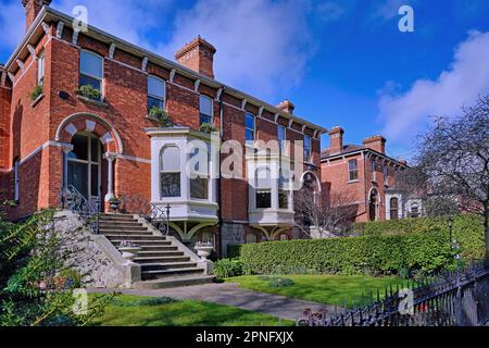 Große Backsteingebäude mit Erkerfenstern Stockfoto