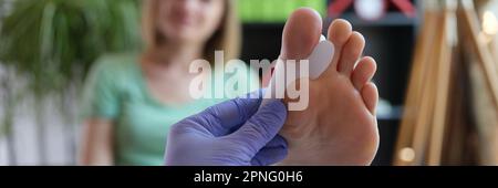 Orthopäde untersucht Bein mit Hallux Valgus-Deformität der Großzehe Stockfoto