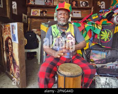 Kingston, Jamaika. 29. März 2023. Auf dem Gelände des Bob Marley Museum sitzt der 79-jährige Reggae-Perkussionist Herman Davis, auch bekannt als Bongo Herman, in seinem Stand und seinen Trommeln. Er verkauft dort Musikaufnahmen und Souvenirs und erzählt Touristen von seiner langen Musikkarriere. (Zu dpa-Korr 'Catch a Fire': Als Reggae vor 50 Jahren in die Welt ging') Kredit: Nick Kaiser/dpa/Alamy Live News Stockfoto