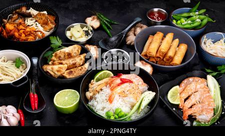 Verschiedene asiatische Gerichte auf schwarzem Hintergrund. Asiatisches Speisenkonzept. Stockfoto