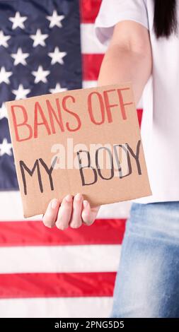 Frau mit einem Schild verbietet My Body amerikanische Flagge auf dem Hintergrund. Protest gegen Abtreibungsverbot. Frauenstreik. Frauen Rechte Freiheit Stockfoto