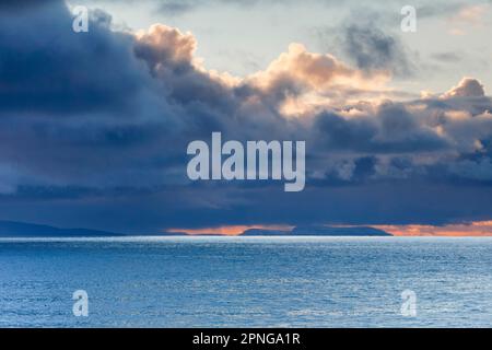 Tief liegende Regenwolken treiben über die Sommerinseln und das offene Wasser des blauen Atlantiks, der Westküste Schottlands Stockfoto