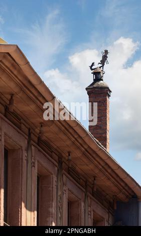 Rotes Backsteingebäude mit Ziegeldach und Kamin in der Stadt Ribeauville, Frankreich Stockfoto