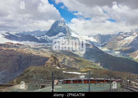 Roter Zug auf dem Hintergrund des Matterhorns in den Schweizer Alpen Stockfoto