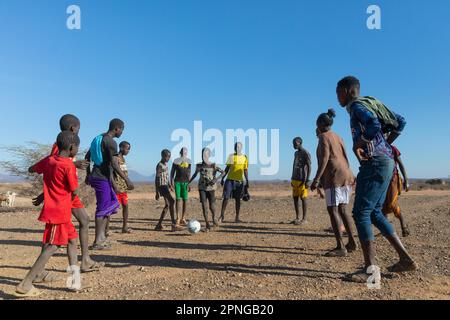 Eine Gruppe junger Männer, die Football spielen, Samburu National Reserve, Kenia Stockfoto