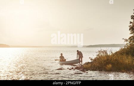 Nichts ist besser als ein Tag Kanufahren. Ein junges Paar, das eine Kanufahrt auf dem See macht. Stockfoto