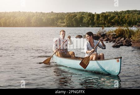 Glück inspiriert von einer Kanufahrt. Ein junges Paar, das eine Kanufahrt auf dem See macht. Stockfoto