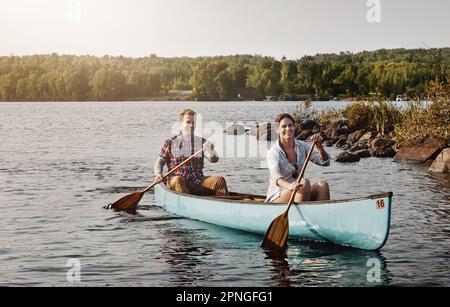 Genießen Sie die Entspannung, die mit einer Kanufahrt einhergeht. Ein junges Paar, das eine Kanufahrt auf dem See macht. Stockfoto