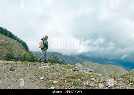 Reifer, bärtiger Reisender, der im Bergwald wandert Stockfoto