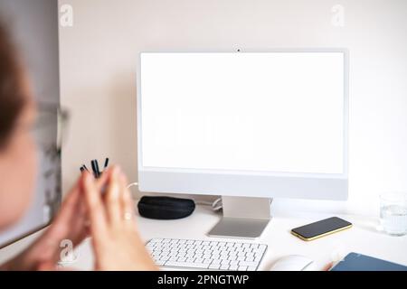 Leerer Bildschirm des Computermonitors und Frau, die auf den Bildschirm schaut. Stockfoto