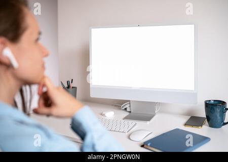Leerer Bildschirm von Computer und Frau, die auf den Bildschirm schaut. Stockfoto