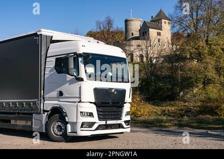 Lastwagen auf dem Hintergrund der Burg. LKW mit Auflieger in grauer Farbe. LKW-Foto für Kalender. Autotransport. Stockfoto