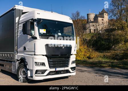 Lastwagen auf dem Hintergrund der Burg. LKW mit Auflieger in grauer Farbe. LKW-Foto für Kalender. Autotransport. Stockfoto