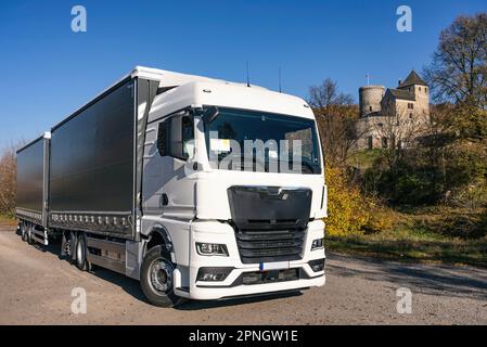 Lastwagen auf dem Hintergrund der Burg. LKW mit Auflieger in grauer Farbe. LKW-Foto für Kalender. Autotransport. Stockfoto