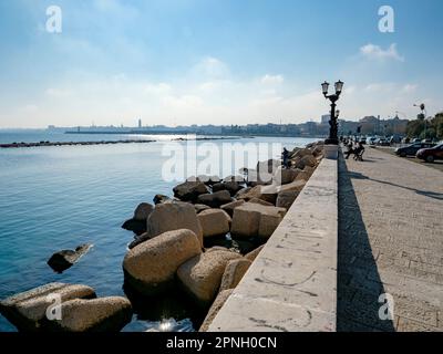 BARI, ITALIEN - 30. OKTOBER 2021: Uferpromenade der Lungomare Imperatore Augusto Straße in Bari, Italien, mit einer schwarzen Straßenlampe und Fischern Stockfoto
