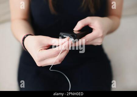 Frau, die ein gefülltes Reservoir in ihre Insulinpumpe steckt Stockfoto