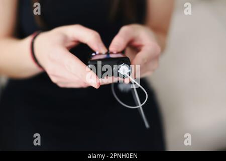 Frau, die ihre Insulinpumpe in den Händen hält Stockfoto