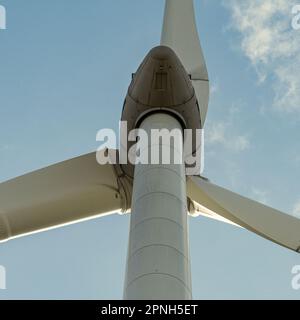 "Erneuerbare Energien in Sicht: Die majestätische Windturbine, die über die Landschaft ragt und saubere Energie für eine nachhaltigere Zukunft liefert." Stockfoto