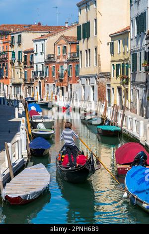 Gondelboot mit Gondoliere auf einem kleinen Kanal, Santa Marta, Venedig, Venetien, Italien Stockfoto