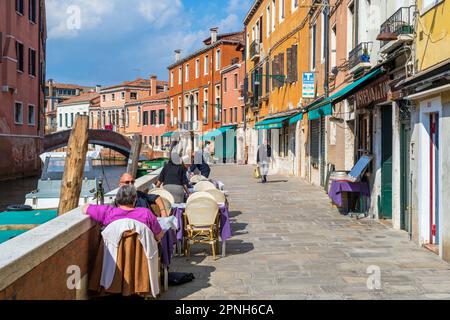 Malerischer Blick auf ein Café-Restaurant im Freien an einem Wasserkanal in Venedig, Venetien, Italien Stockfoto