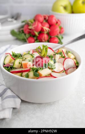 Rettichsalat mit Gurke und Äpfeln in einer Schüssel Stockfoto