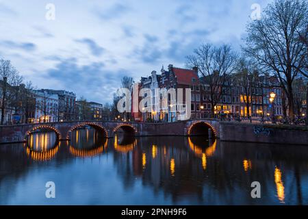 Im April erleuchteten die Brücken zur Abenddämmerung in Amsterdam, Holland, Niederlande - lange Exposition Stockfoto