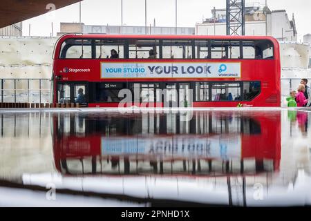 London, Großbritannien. 19. April 2023 Passanten und ein Bus spiegeln sich in einem Wasserspiel in der City of London wider, das unter dem aufsteigenden Wasser zu liegen scheint. Aktivisten des Aussterbens Rebellion, die mit anderen Kampagnengruppen zum Klimawandel zusammenarbeiten, haben „The Big One“ angekündigt, eine Reihe von Veranstaltungen, die am Wochenende in Westminster stattfinden und die britische Regierung auffordern, Maßnahmen gegen die Auswirkungen des Klimawandels und die Auswirkungen auf den steigenden Meeresspiegel zu ergreifen. Kredit: Stephen Chung / Alamy Live News Stockfoto