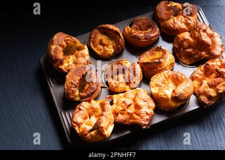 Speisekonzept hausgemachter Yorkshire Pudding auf schwarzem Hintergrund mit Kopierbereich Stockfoto