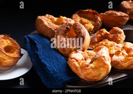 Speisekonzept hausgemachter Yorkshire Pudding auf schwarzem Hintergrund mit Kopierbereich Stockfoto