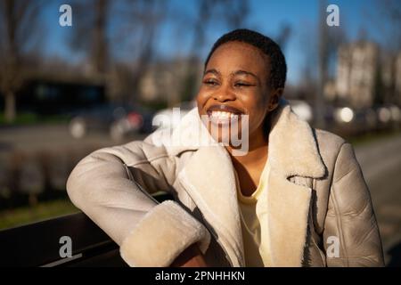 Nahaufnahme einer glücklichen schwarzen Frau im Freien. Sie genießt die Sonne und die frische Luft. Stockfoto