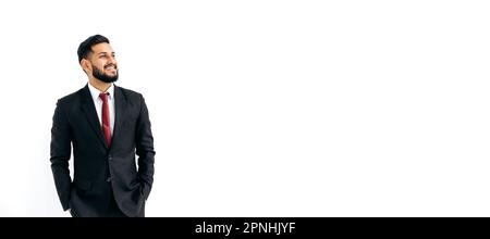 Panoramafoto eines positiven, eleganten, einflussreichen arabers oder indianers im Anzug, auf isoliertem weißen Hintergrund stehen, wegschauen, denken, planen, träumen, Lächeln. Kopierraum für Ihre Präsentation Stockfoto