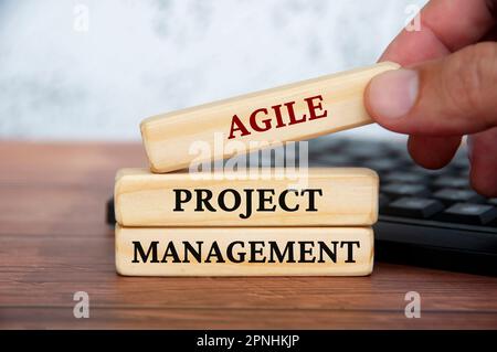 Agile Projektmanagementtexte auf Holzblöcken mit Tastatur und Holzdeckelhintergrund. Geschäftskultur und Konzept für operative Exzellenz. Stockfoto