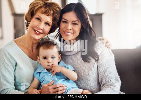 Die Bindung über die Jahre hinweg stark zu halten. Ein bezauberndes Mädchen, das sich mit ihrer Mutter und Großmutter zu Hause verbindet. Stockfoto