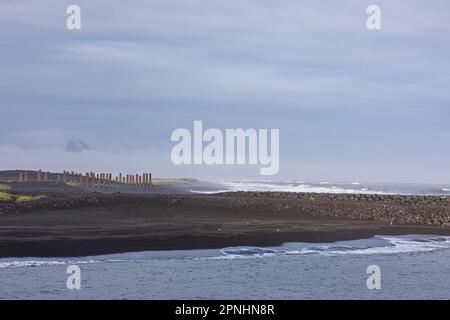 Künstliche Säule in Island auf schwarzem Sand, mit Kosten rechts Stockfoto