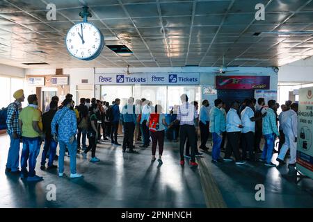 Leute, die sich am Ticketschalter der Ramakrishna Ashram Marg Metro Station in Delhi, Indien anstellen. Stockfoto