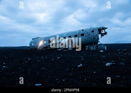 Lichteffekt in der Nacht des alten Flugzeugwrack, das an einem abgelegenen schwarzen Sandstrand in Island verlassen wurde Stockfoto